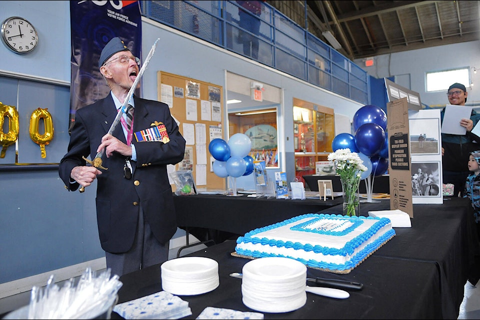 Lieut.-Col. Jack Jackaman, 91, licks the icing off a sword after using it to cut a cake at the 100th anniversary celebration for the Royal Canadian Air Force at the Princess Armouries in Chilliwack on Saturday, April 27, 2024. The event was hosted by the 147 Airwolf Royal Canadian Air Cadets and 879 (Earl MacLeod) Wing RCAFA. (Jenna Hauck/ Chilliwack Progress) 