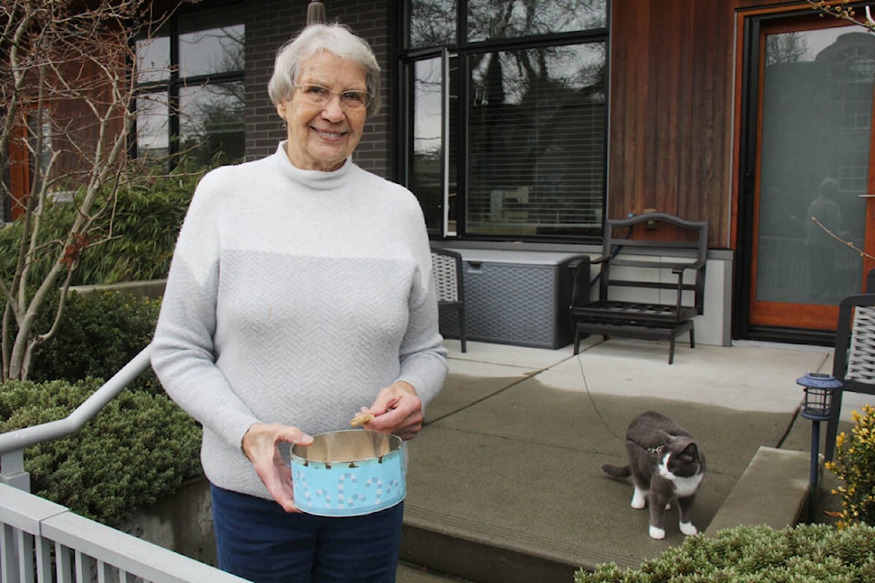Florence Boylan, 94, keeps a tin full of dog treats on the street for passersby. Carl, who also lives in the Oak Bay Avenue home, isn’t as big of a fan of dogs, and keeps watchful eye. (Christine van Reeuwyk/News Staff) 