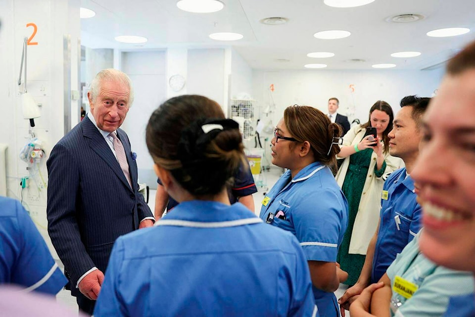 FILE - Britain㽶Ƶֱs King Charles III meets with staff members during a visit to the University College Hospital Macmillan Cancer Centre in London, Britain, Tuesday,April 30, 2024. King Charles III㽶Ƶֱs decision to be open about his cancer diagnosis has helped the new monarch connect with the people of Britain and strengthened the monarchy in the year since his dazzling coronation at Westminster Abbey. (Suzanne Plunkett/Pool photo via AP, File) 