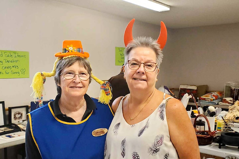 Lesley Hannas, left, and Diane Martineau have fun while volunteering at the OAPO clothing and garage sale Saturday, April 27. (Monica Lamb-Yorski photo - Williams Lake Tribune) 