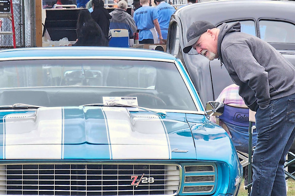 A car fan took a close look at a classic muscle car, one of more than 400 vehicles registered for the 62nd D.W. Poppy car show and school fundraiser held Sunday, May 5. (Dan Ferguson/Langley Advance Times) 