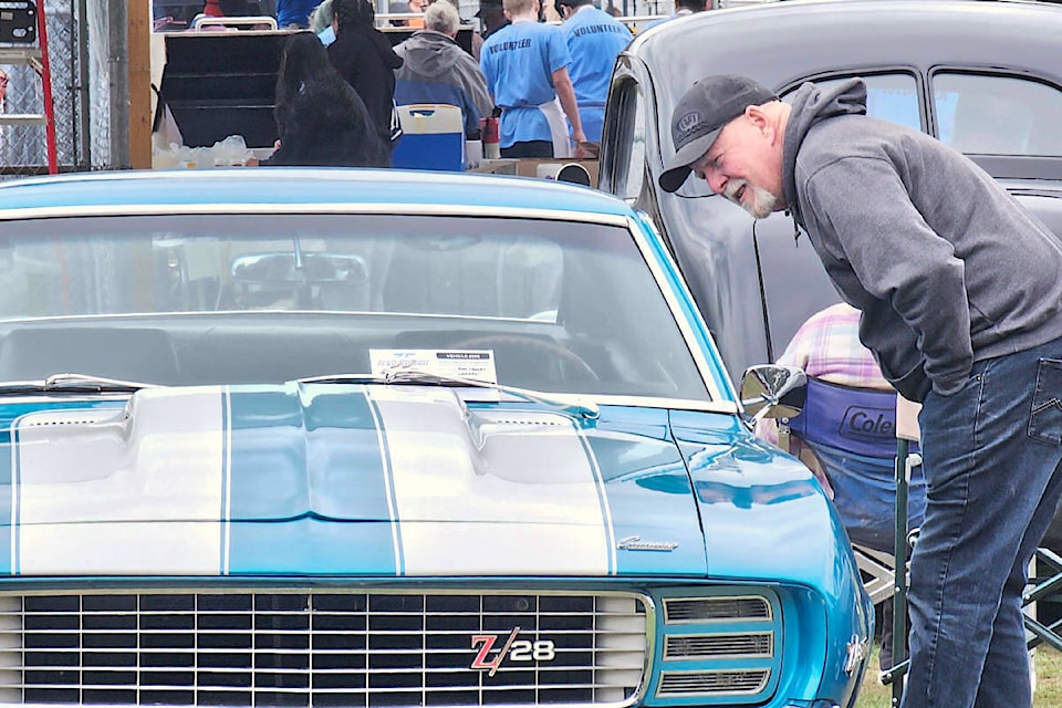 A car fan took a close look at a classic muscle car, one of more than 400 vehicles registered for the 62nd D.W. Poppy car show and school fundraiser held Sunday, May 5. (Dan Ferguson/91ԭ Advance Times) 