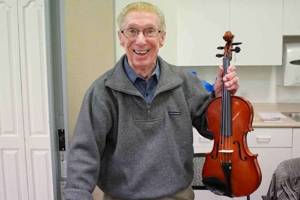 Peter Rubenuik was trying to sell his refurbished violin at the community garage sale event at the Maple Ridge Seniors Activity Centre on May 4. (Brandon Tucker/The News) 