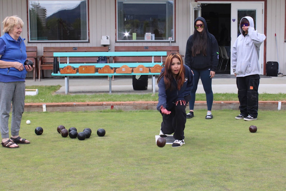 Lawn bowling coach Robin Forrest, left, and students Karen McGregor, second from right, and Isabella Noddin watch Tisha Titian deliver a bowl during an open house on Wednesday, May 1, 2024 at the lawn bowling pitch in Port Alberni. (SONJA DRINKWATER PHOTO) 