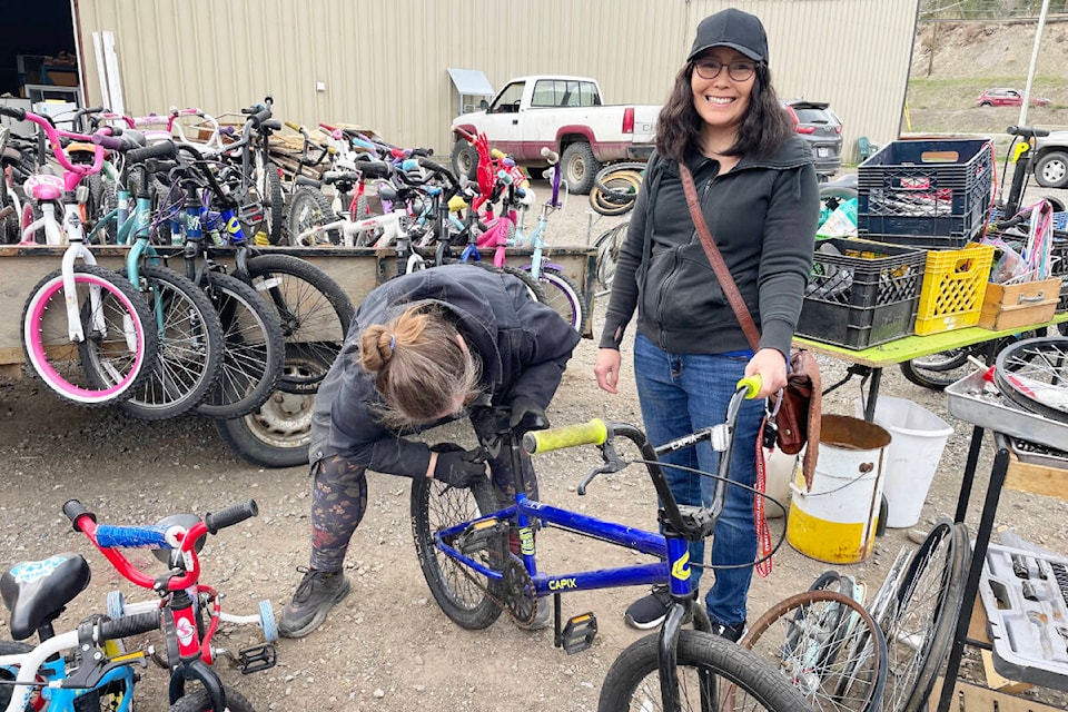 Maxine Sellars, right, gets some help with a new bike for her from Mary Forbes as part of the Bikes for All program supported by the Cariboo Regional District and city of Williams Lake. (Ruth Lloyd photo - Williams Lake Tribune) 