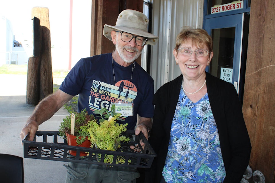 Bob Perkins and Shirley Reimer, members of the Mt. Klitsa Garden Club, were in charge of collecting payment for purchasesin this case foliage. (SONJA DRINKWATER PHOTO) 