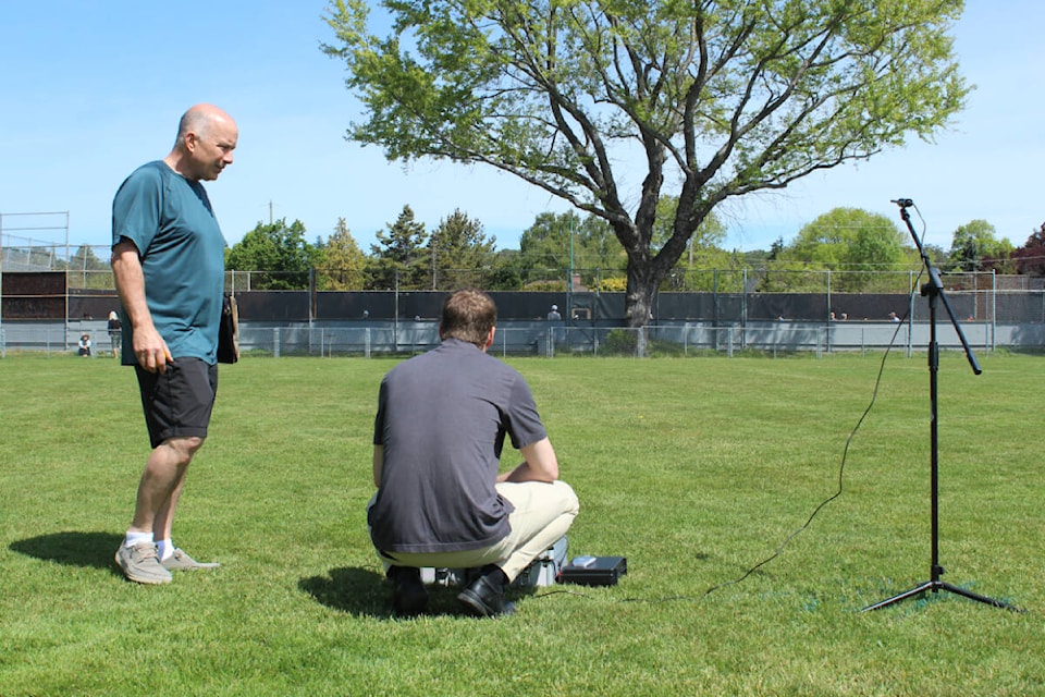 Andy Magee of the Saanich Peninsula Pickleball Association stands as engineer Jordan Mikkers gets his sound measuring equipment ready. (Mark Page/News Staff) 