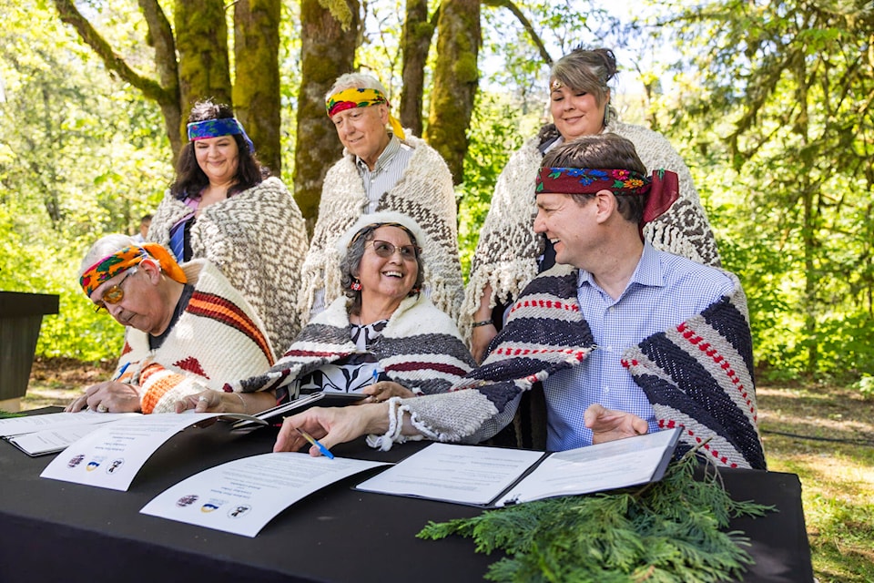 Chief Pahalicktun (Richard Thomas) of the Lyackson First Nation, Chief Sulsulxumaat (Cindy Daniels) of Cowichan Tribes, and Premier David Eby sign a land-transfer deal at Skutz Falls. The back row from left includes Laxele’wuts’ aat (Shana Thomas) of the Lyackson First Nation, Murray Rankin, minister of Indigenous Relations and Reconciliation, and Sunaxwumaat (Dana Thorne) of Cowichan Tribes. (Felipe Fittipaldi photo) 