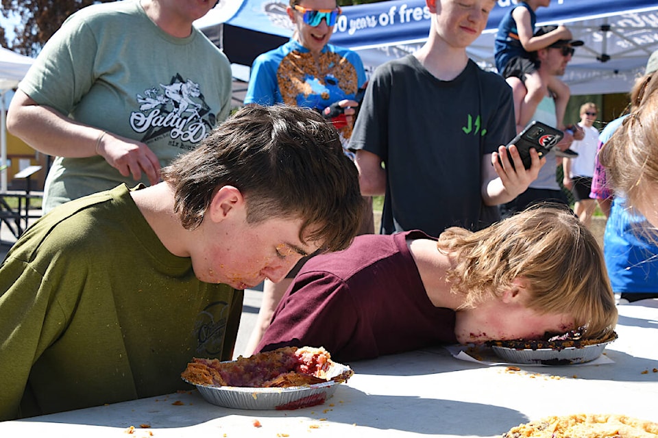 Two-time winner in the teen/adult category, 2022 champ Ty Dunlop, left, powers through his pastry while friend and fellow competitor Reef Paetsch goes all out with face plant during the Pie Eating Contest at the Salty Dog Street Fest in downtown Salmon Arm Saturday, May 11. (Heather Black-Salmon Arm Observer) 