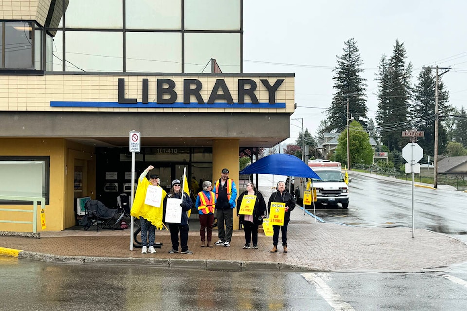 Cariboo Regional District staff man a picket line Wednesday morning, May 15 in downtown Quesnel. (Tracey Roberts photo-Quesnel Observer) 