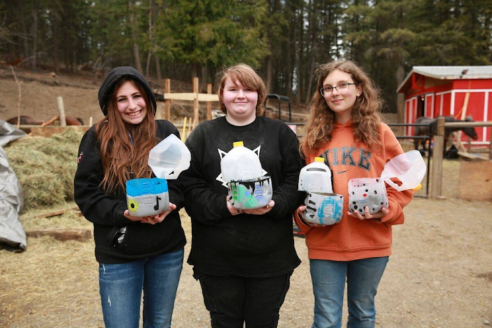 Charles Bloom students Sierra (left), Taya, and Annabelle created mini-greenhouses from recycled milk jugs and planted them with lettuce, kale, poppies, annd sweet peas. (Contributed) 
