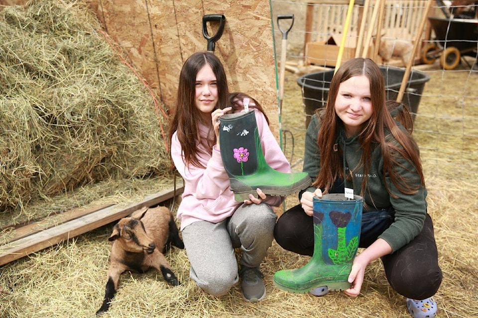 Charles Bloom students Isabelle (left) and Sierra painted repurposed rubber boots and planted them with pollinator-friendly zinnias, nasturtiums, and pansies. (Contributed) 
