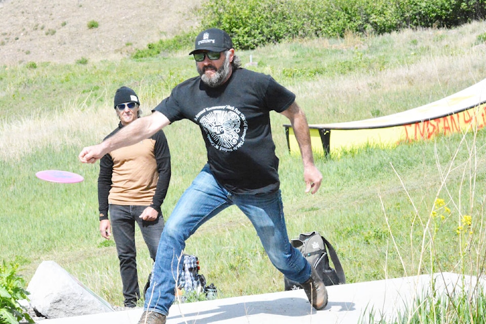 Jesse Hill from Wells throws a disc while Merle McAssey of Williams Lake awaits his turn at Boitanio Park during the May long weekend tournament. (Monica Lamb-Yorski photo - Efteen) 