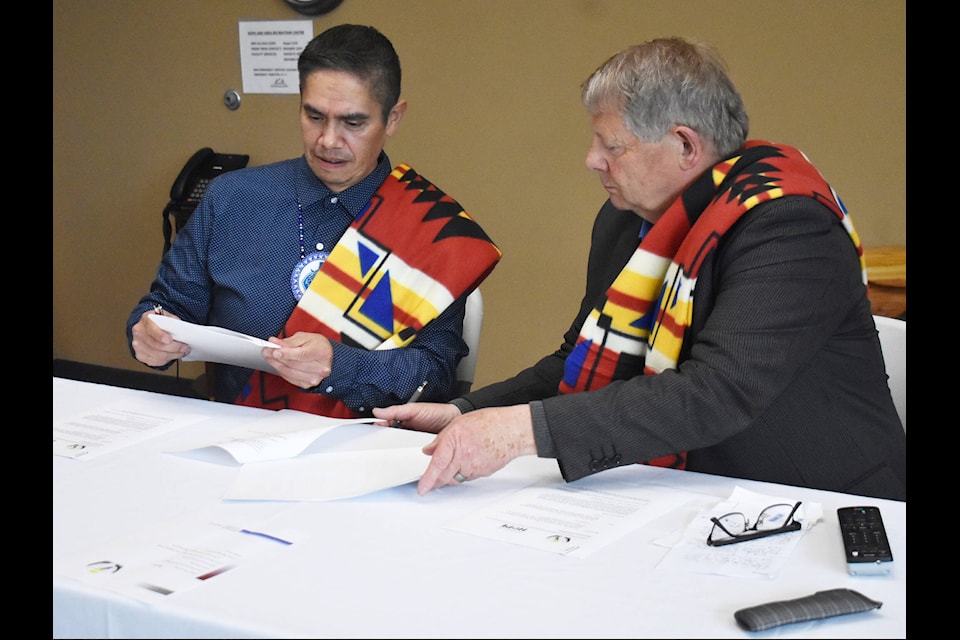 Chawathil First Nation Chief Norman Florence (left) and Hope Mayor Victor Smith (right) sign the memorandum of understanding. (Kemone Moodley/Hope Standard) 