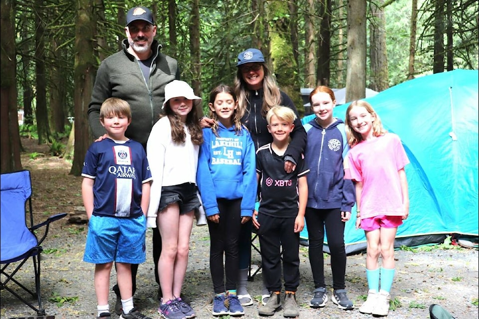 Kevin Armstrong and Gillian Dolding pose by the fire with the two family’s children. (Tim Collins/Contributed) 