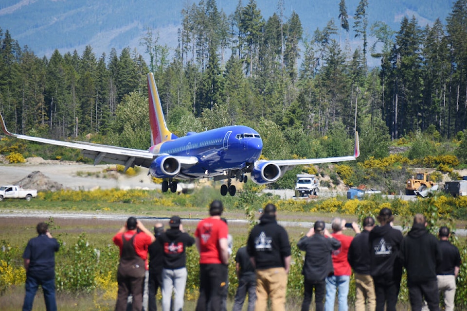 A crowd of Coulson Aviation staff members watch as a Boeing 737-700still dressed in Southwest Airlines colourstouches down at the Alberni Valley Regional Airport on Wednesday, May 22, 2024. Coulson will convert the aircraft to a large air tanker for aerial firefighting. (SUSIE QUINN/ Alberni Valley News) 
