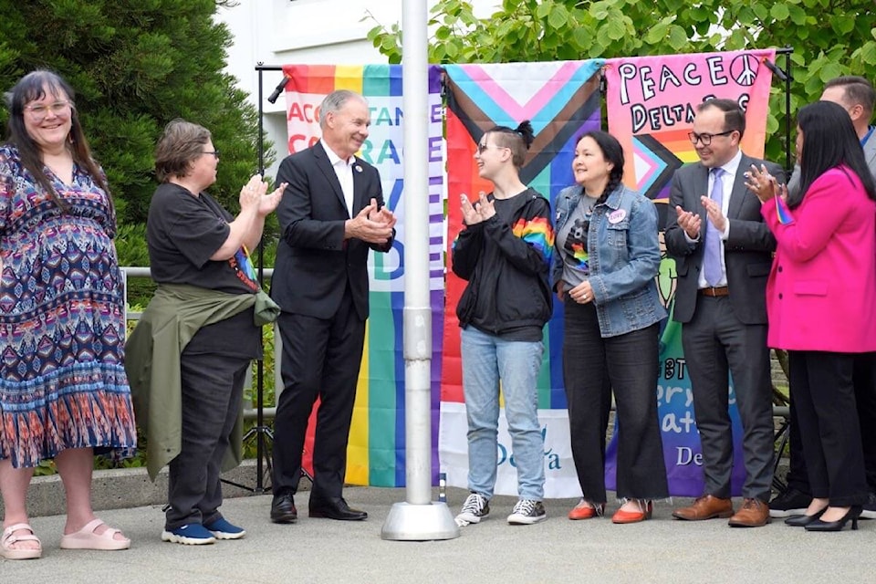 (from left) Delta School District SOGI co-ordinator Trevana Spilchen, former City of Delta corporate social planner Gillian McLeod, Mayor George Harvie, Sands Secondary student Trin Van Rheenen, Delta Pride Society board member Christa Horita Kadach and Delta councillors Dylan Kruger, Jennifer Johal and Daniel Boisvert celebrate after raising the Progress Pride flag at Delta city hall on Monday, May 27, 2024. (James Smith/North Delta Reporter photo) 