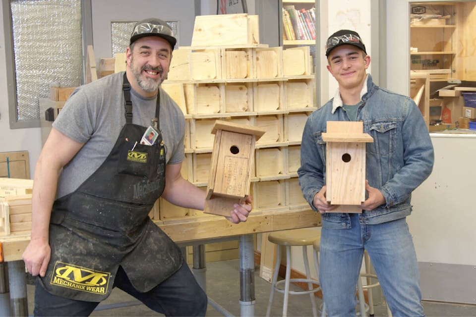 LCSS woodworking student Sam Holmes and his instructor Mr. Hutchinson display two of the 64 houses that the students built for the Williams Lake Field Naturalist’s Bluebird Program (Loyd Csizmadia photo) 