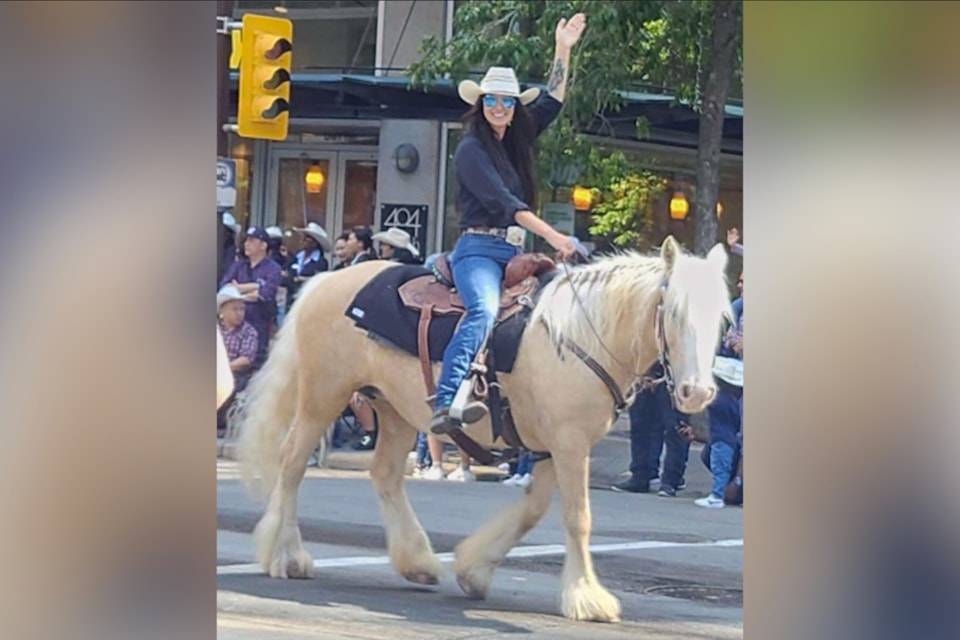 Aimee Beauchamp waves to the crowd at the Calgary Stampede parade, astride NF Aurora, a Gypsy Cob. 