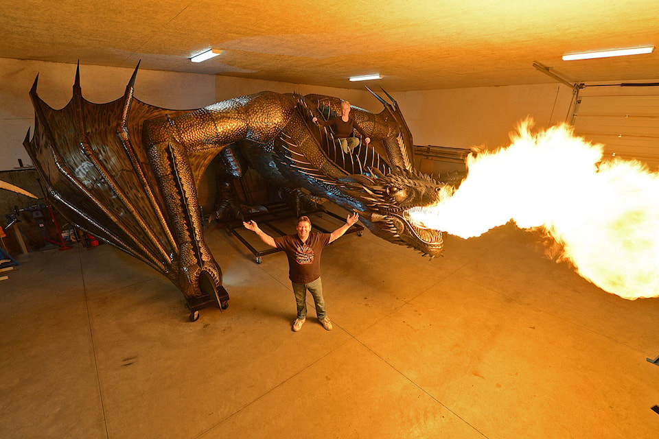 Kevin Stone and wife Michelle (sitting on dragon) pose for a photo with their 15,000-pound, fire-breathing steel dragon named ‘Drogon’ on Dec. 15, 2022 which took more than two years to complete. Drogon is from the hit HBO TV show Game of Thrones. Stone’s popular sculpture has been seen by people around the world via photos and videos they posted to social media of Drogon in the making. (Jenna Hauck/ Chilliwack Progress)