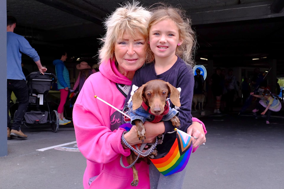 Cheryl (left) and Luna smile with their five-year-old mini dachshund, Buddy.