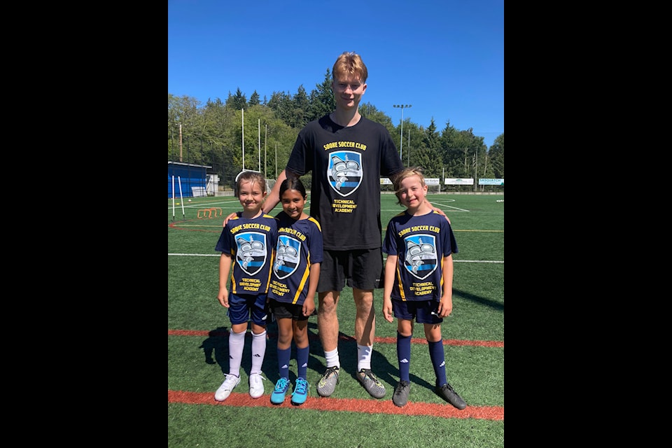 Ketil Eckhardt, the new technical director for the Sooke Soccer Club, Lola Crow, Jaya Chumber, and Olympia Crow, sport the club's new logo and design. (Contributed/Sooke Socccer Club)