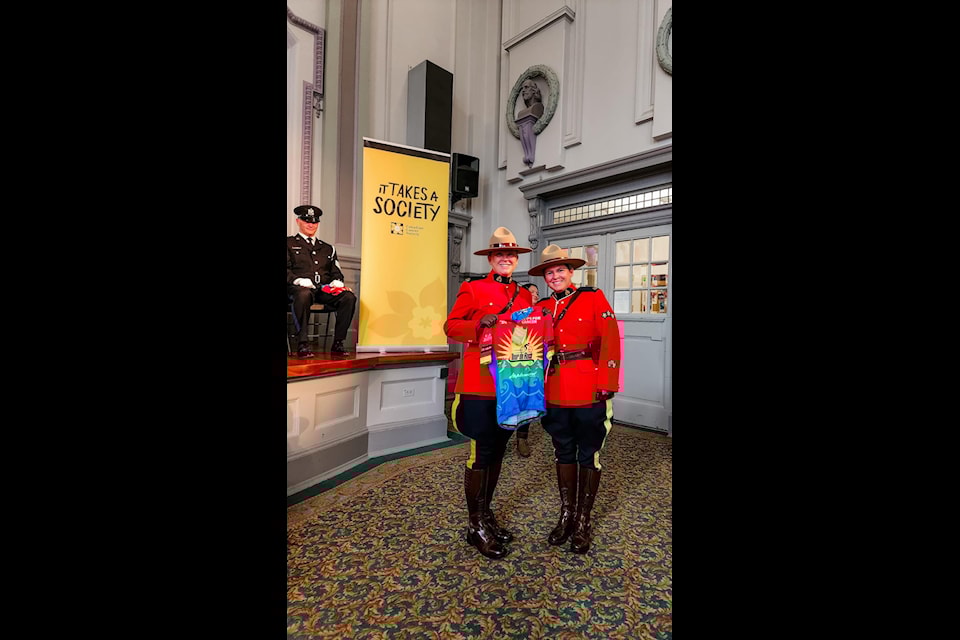 Sooke RCMP Const. Mary-Ellen Somerville receives her Tour de Rock jersey from Sooke RCMP Sgt.Kara Gubbins, an alumni rider with the Tour de Rock. (Mary-Ellen Somerville/Contributed)