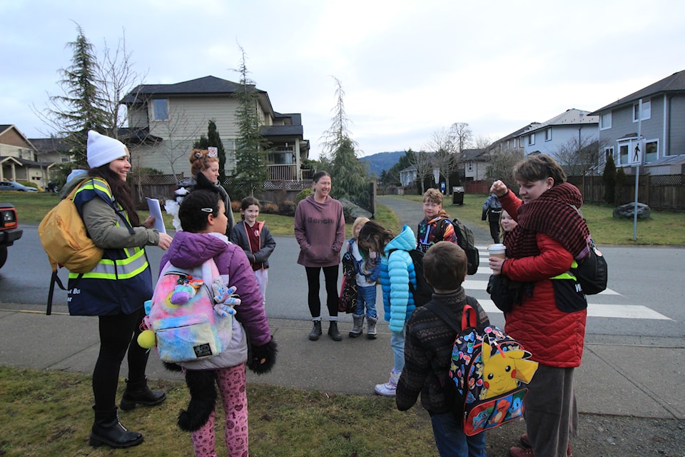 Parents, walking school bus leaders and kids gather before departing for school.
