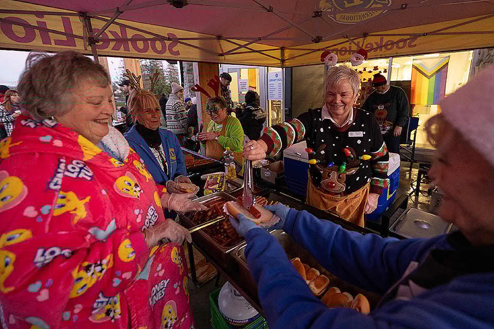From left to right. Shelly Henss, Bev Lewis, Joanne Halliday, Rachel Moir and Maxine Medhurst of the Sooke Harbourside Lions serve hotdogs to the public before the 2024 Sooke Silver Bells Santa Claus Parade in Sooke. (Arnold Lim / Sooke News Mirror)