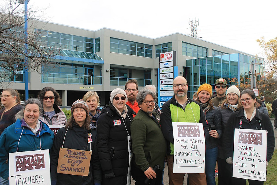 Saanich Teacher’s Association President Don Peterson (fifth from right, in green jacket) leads a group of protesters outside South Saanich MLA Lana Pophams office on Thursday, Nov. 14. (Sophie Heizer/News Staff)