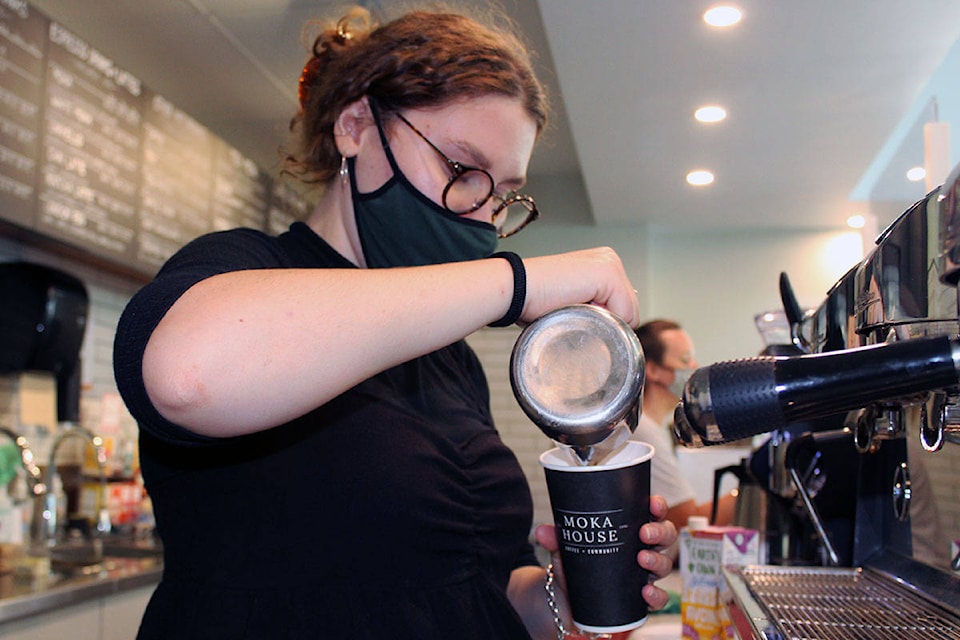 Amara Digout, barista at the new Moka House location in Cadboro Bay, makes a morning latte for a customer. (Megan Atkins-Baker/News Staff)