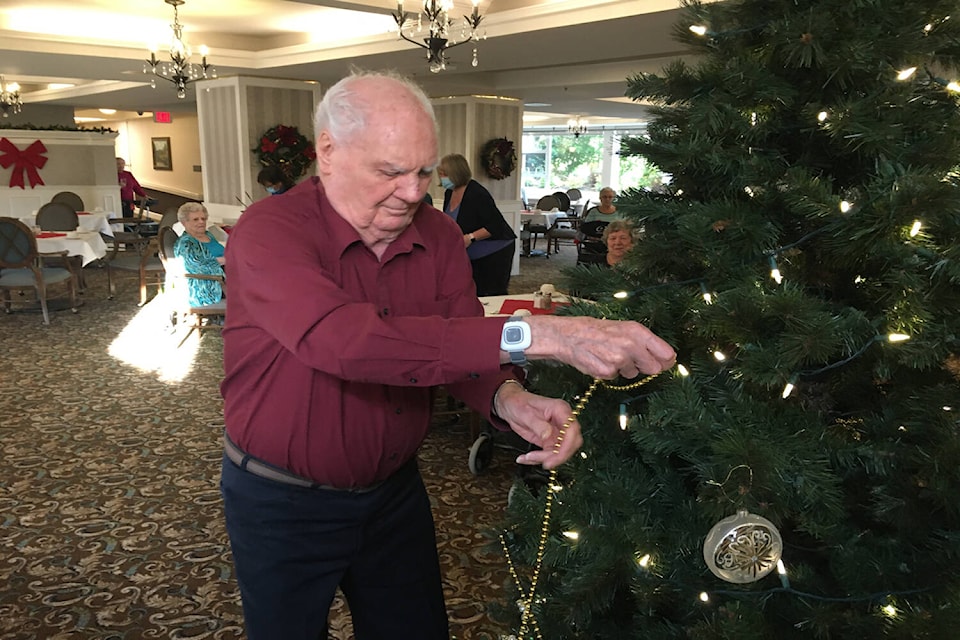 Gerald Moreau helps trim the tree at Parkwood Place by Revera. (Dan Ebenal/News Staff)