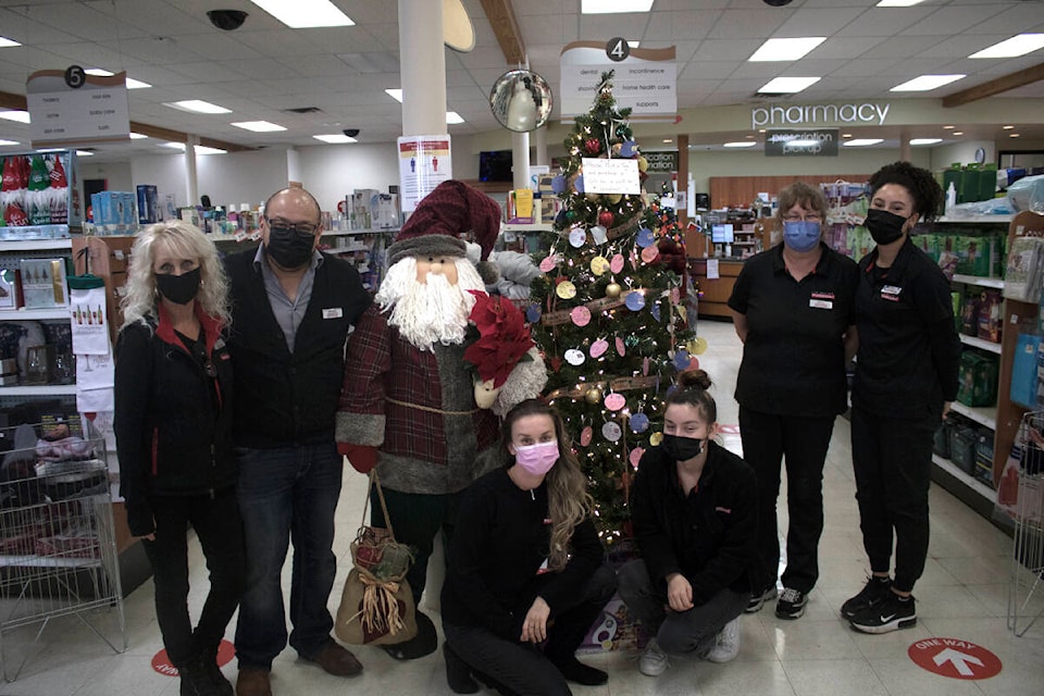 Mohamed Zeid (second from left) with staff members at Pharmasave Sooke, next to one of the three Christmas wish trees. (Bailey Moreton - Sooke News Mirror)