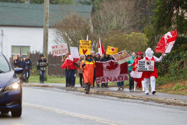 A group of vaccine mandate demonstrators make their way up Highway 14 to the Evergreen Centre Wednesday afternoon in response to SD62’s newly announced vaccine requirement. (Justin Samanski-Langille/News Staff)