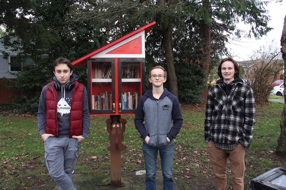Oak Bay High students Noah Scott, left, Henry Baker and Evan Warburton stand with the little free library they built together, in Victoria’s Redfern Park. (Christine van Reeuwyk/News Staff)