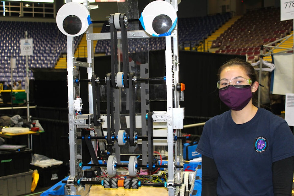 Julianna Kwan, team captain and Reynolds Secondary student, stands next to the industrial-size robot she and her team built for the FIRST Robotics Competition. (Megan Atkins-Baker/News Staff)