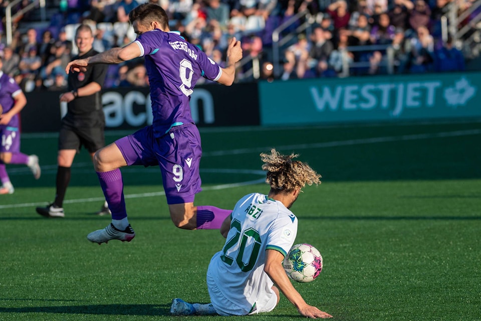 Alejandro Diaz hurdles a challenge from York United’s Diyaeddine Abzi during the Pacific FC versus York United match at Starlight Stadium on May 20, 2022. (Simon Fearn/Black Press Media)