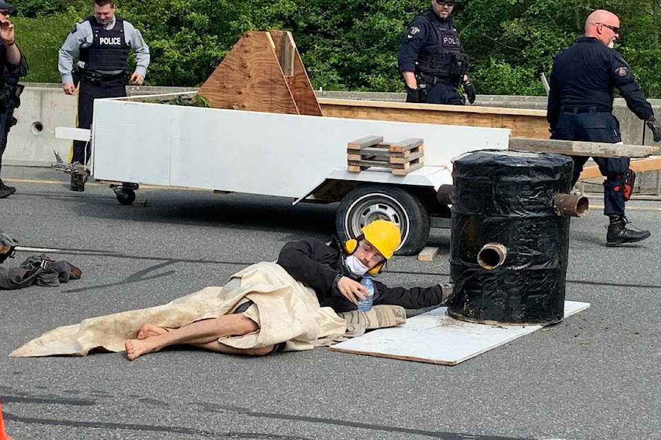 A Save Old Growth protester encased their arm in a concrete-filled barrel as part of Monday’s North Saanich blockade. (Wolf Depner/News Staff)