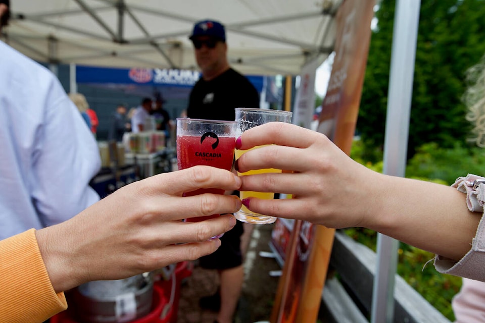 Langford Beer Festival attendees cheers before sampling some B.C. craft beer Saturday at Starlight Stadium. (Justin Samanski-Langille/News Staff)