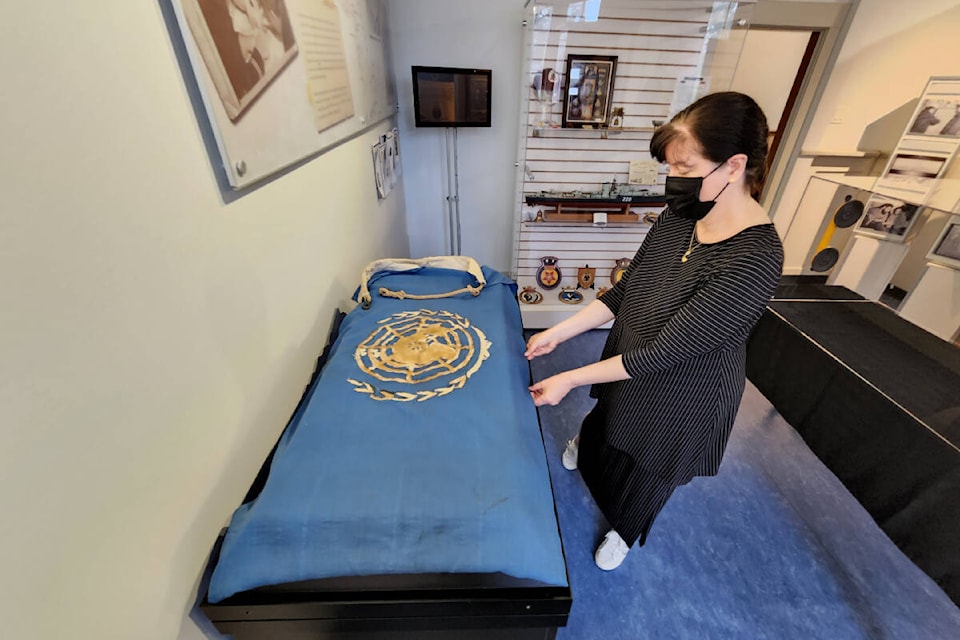 CFB Esquimalt Naval and Military Museum head curator Tatiana Robinson arranges a unique handmade 1950s UN flag flown by HMCS Sioux during the Korean War. The museum highlighted the flag for National Peacekeepers’ Day this year. (Courtesy CFB Esquimalt)