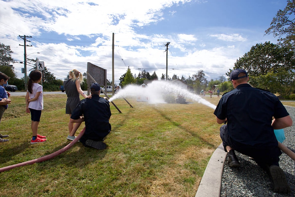 Kids try out a fire hose during an open house at the North Saanich Fire Department fire hall Saturday celebrating the department’s 50th anniversary. (Justin Samanski-Langille/News Staff)