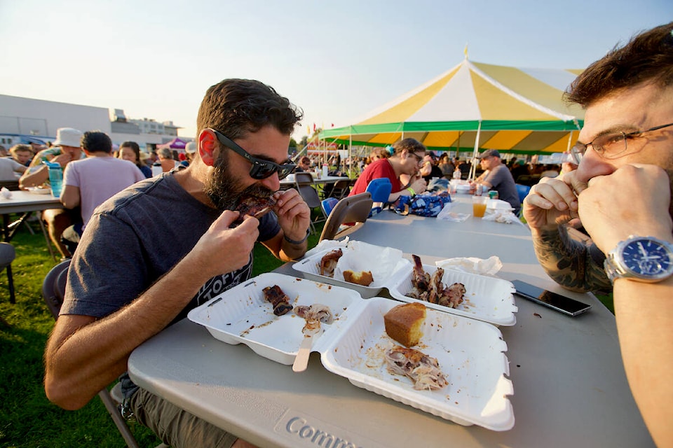 Ami and Leeam Dagan enjoy some ribs Friday at Esquimalt Ribfest. (Justin Samanski-Langille/News Staff)