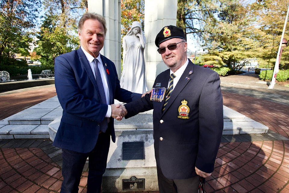 Royal Canadian Legion Branch 91 president Norm Scott presents Langford Mayor Stew Young with the ceremonial first poppy at the Langford Cenotaph Friday (Oct. 28) officially launching this year’s poppy campaign. (Justin Samanski-Langille/News Staff)
