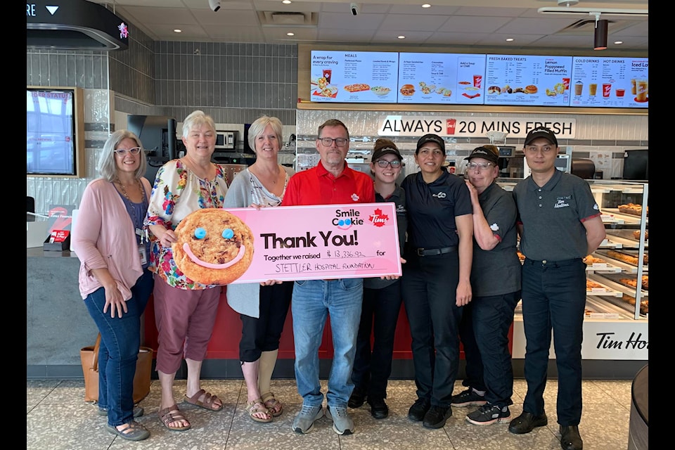 SHSF members Janet Chaney, Mary-Jane Jackson, and Cheryl Barros receive a Smile Cookie donation cheque from Stettler Tim Hortons owner Bob Carey and some of his staff. 