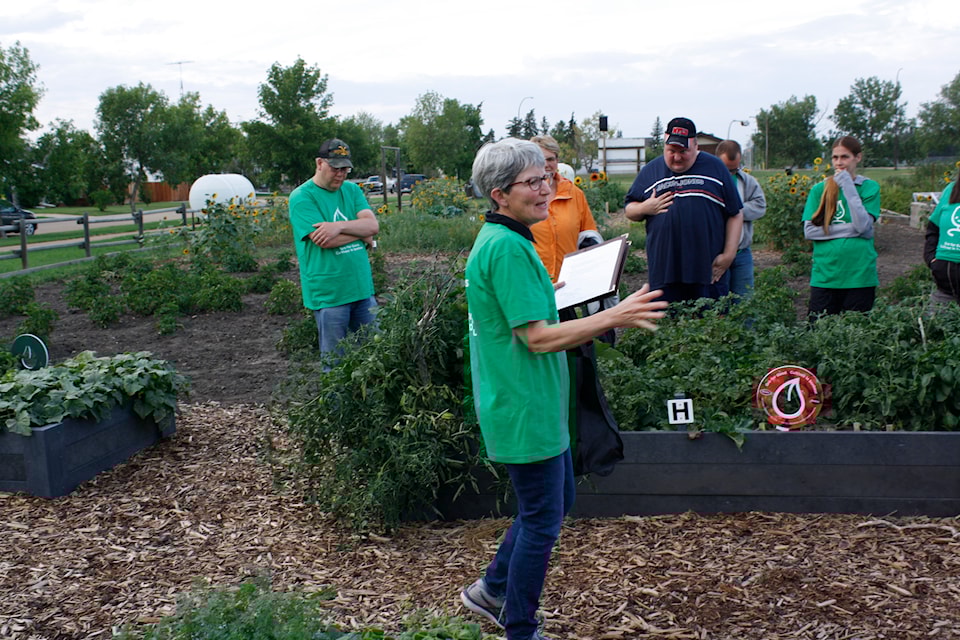 Heartland Beautification chairperson Grace Fix addresses community members at the Central Garden.