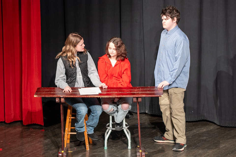 Dahlia, played by Kenna Hansel (mid), is struggling with her algebra homework as her parents, played by Autumn Tanner and Darian McKay struggle to help her.