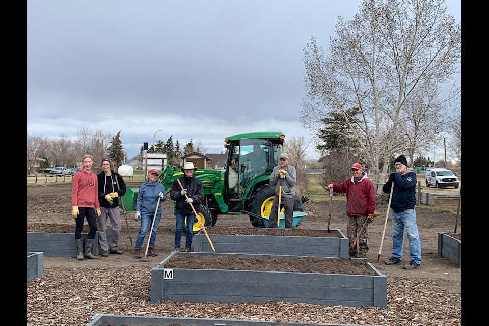 Heartland Beautification Committee volunteers work on placing new raised garden beds in one of the community gardens.
