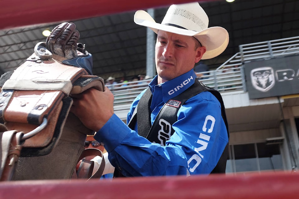Bareback rider Jake Vold prepares his saddle before the bareback riding event. (File photo)