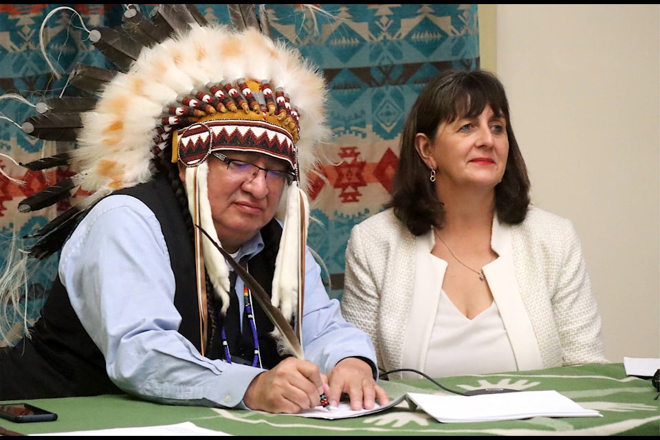 Chief Desmond Bull, left, signs the agreement with Catherine Lappe, assistant deputy minister for Indigenous Services Canada, Feb. 1. (Photos by Emily Jaycox/BLACK PRESS NEWS MEDIA)