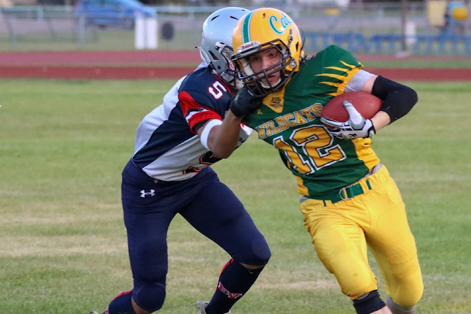 Stettler Wildcat Taylor Watt runs the ball while holding off Bonnyville Voyageur Jon Degamo. (Kevin Sabo/Stettler Independent)